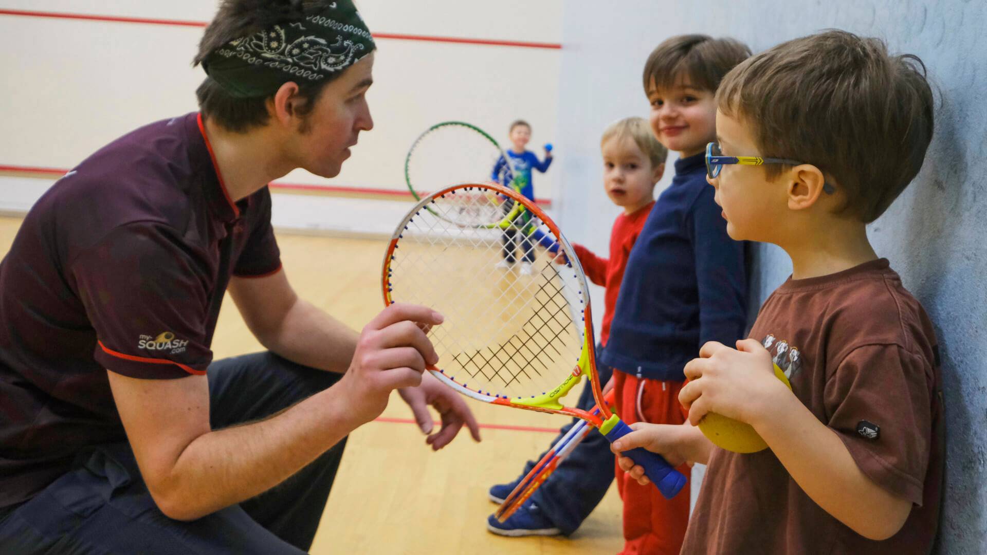 éducateur sportif avec des enfants pendant une animation tennis
