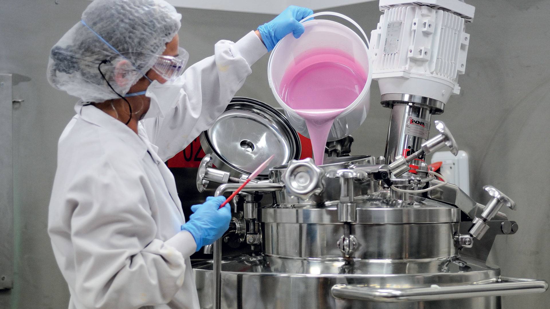Technicienne qui verse une crème dans une machine